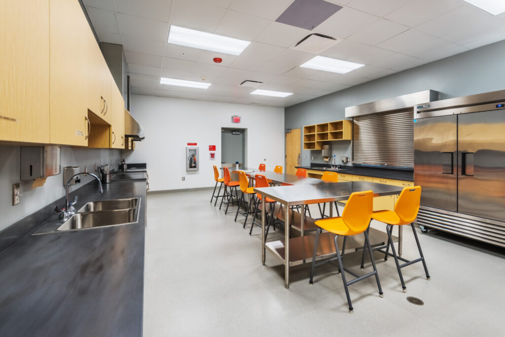 Apex Senior Center Kitchen with a Commercial Refrigerator, Oven, Stove Top, Multiple Sinks, and a Serving Window