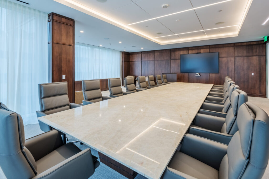 Glenlake Seven Martin Marietta Headquarters Conference Room with Wood Paneling, a Long Table and Seating, and a Mounted Screen