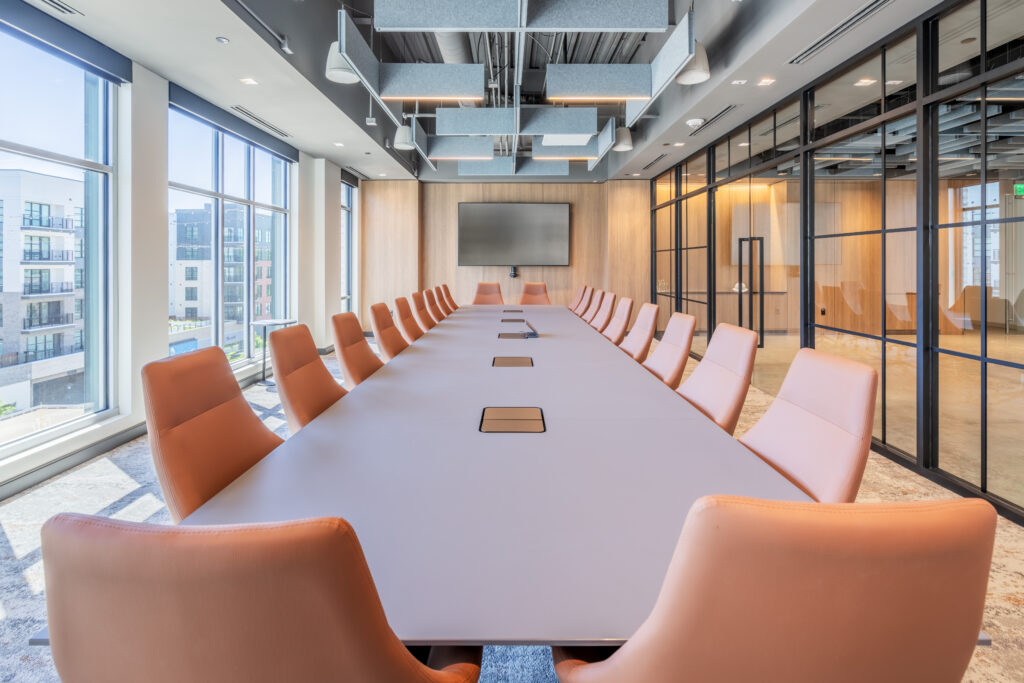 Large Conference Room with Orange Chairs and Exposed Ceiling