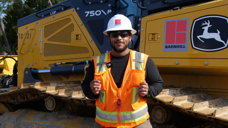 Construction Worker in front of Heavy Equipment